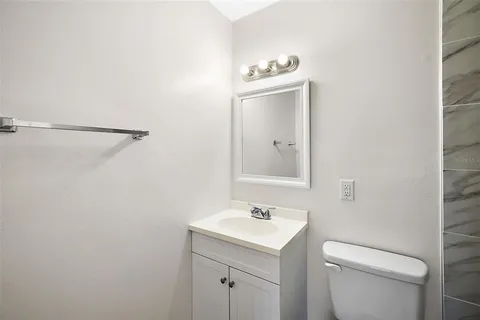a bathroom with a toilet a sink and mirror