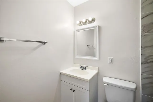 a bathroom with a toilet a sink and mirror