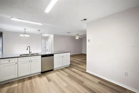 a large white kitchen with sink and dishwasher