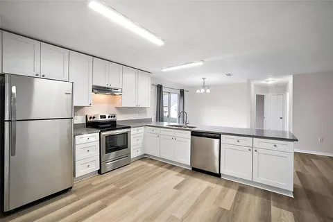 a kitchen with white cabinets stainless steel appliances and sink