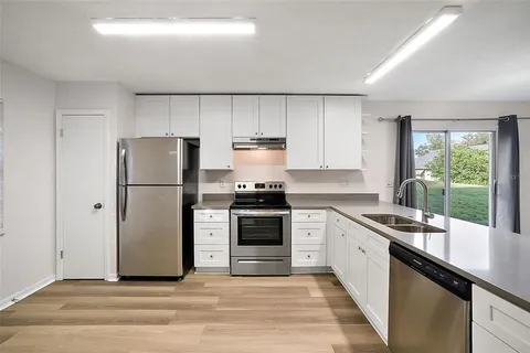 a kitchen with a refrigerator sink and cabinets