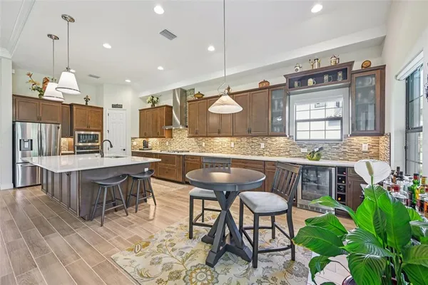 a kitchen with kitchen island granite countertop wooden cabinets and a refrigerator