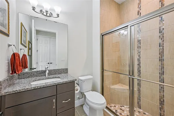 a bathroom with a granite countertop sink mirror vanity and toilet