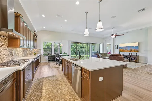 a large kitchen with kitchen island a stove a sink a center island and living room view