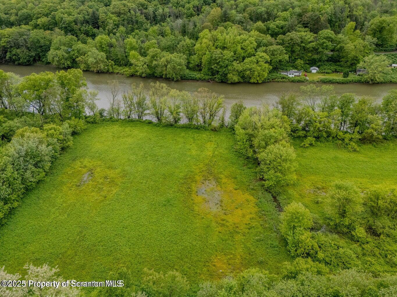 436 State Line Road Susquehanna, PA 18847 - Photo 9 of 13 a view of a lake with a yard and large trees
