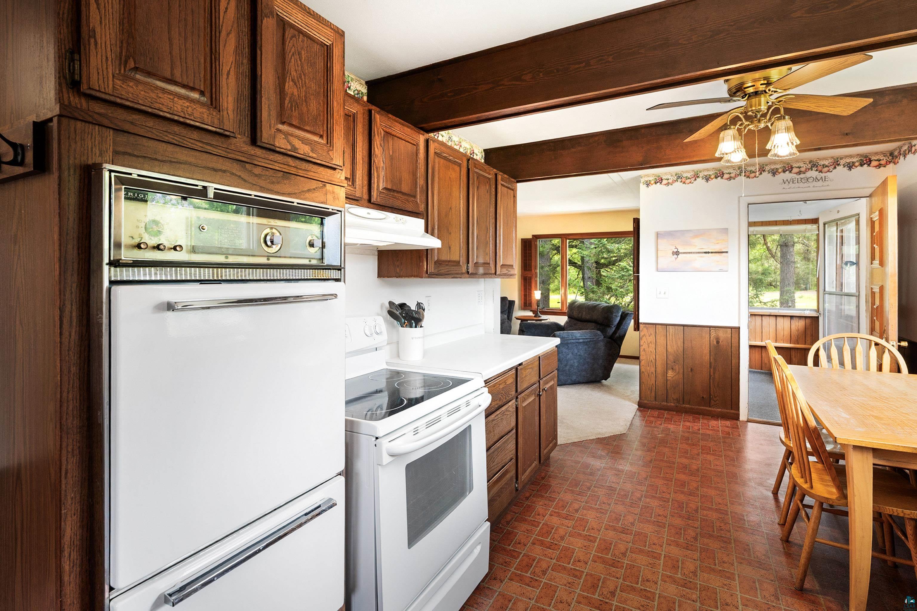 4808 Midway Road Duluth, MN 55811 - Photo 11 of 57 Kitchen featuring dark wood cabinetry, white countertops, white built-in oven, and a white electric range