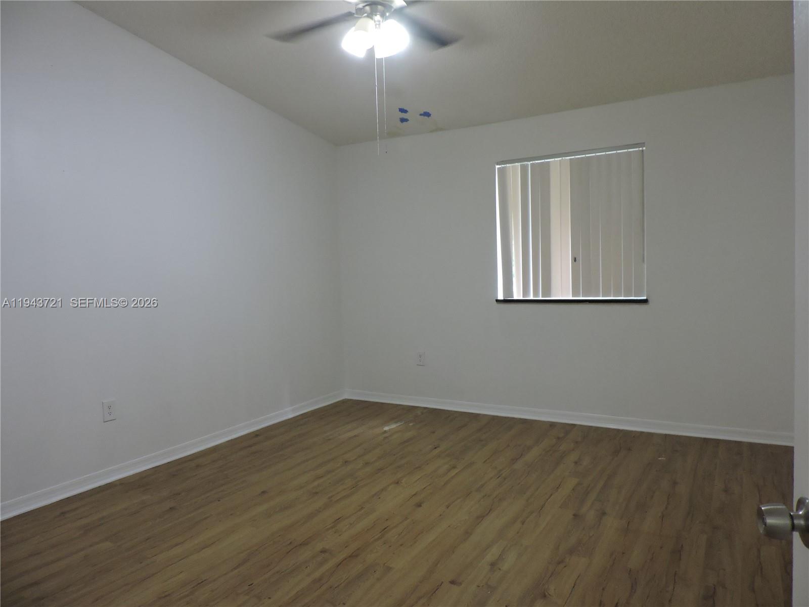 17975 Southwest 140th Court, Unit 17975 Miami, FL 33177 - Photo 21 of 27 wooden floor in an empty room with a window