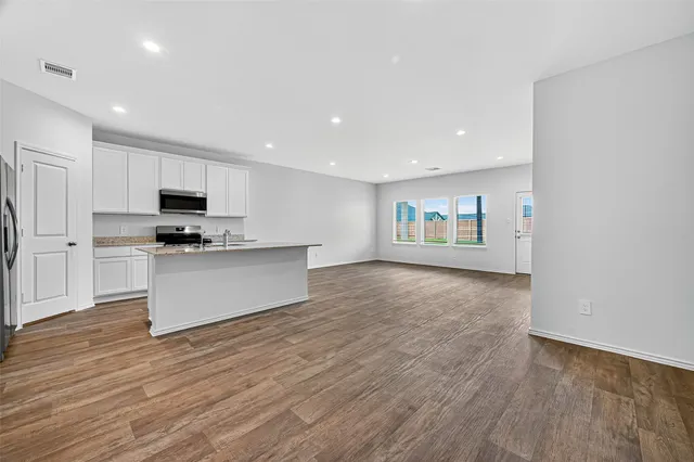a view of kitchen with granite countertop stainless steel appliances and sink