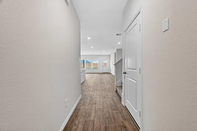 a view of a hallway with wooden floor
