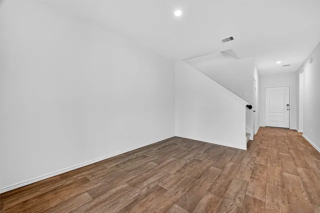 a view of empty room with wooden floor