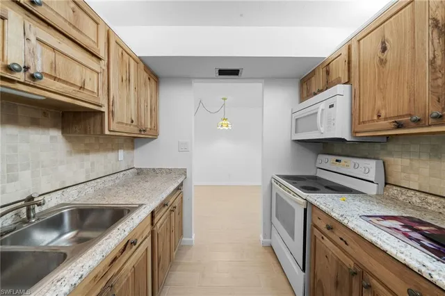 a kitchen with stainless steel appliances granite countertop a sink a stove and a microwave