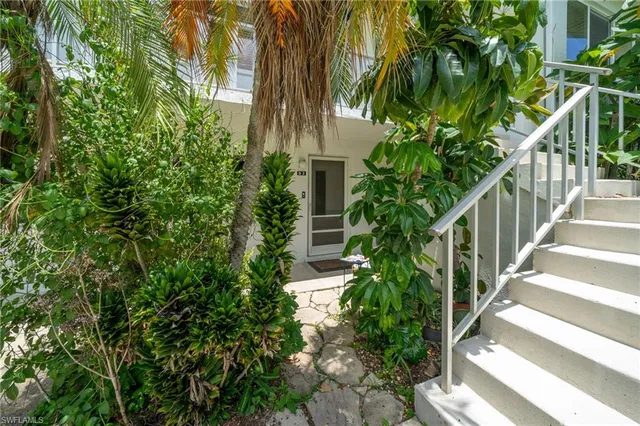 a view of a pathway of a house with flower plants
