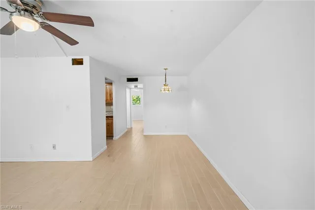 en empty room with ceiling fan and window