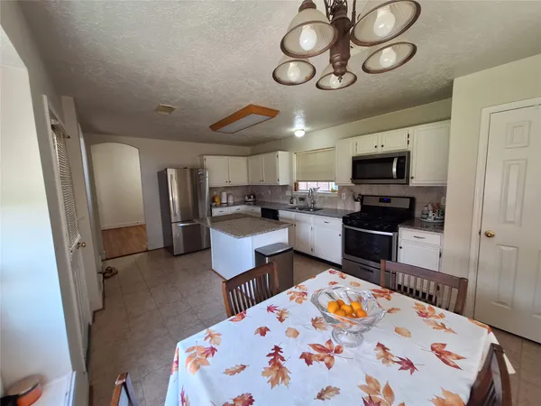 a kitchen with stainless steel appliances granite countertop a stove a refrigerator a sink a stove a microwave and a refrigerator