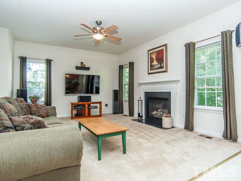 4728 Drewbridge Way Raleigh, NC 27604 - Photo 12 of 15 a living room with furniture a fireplace and a flat screen tv