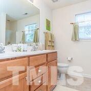 4728 Drewbridge Way Raleigh, NC 27604 - Photo 4 of 15 a bathroom with a granite countertop sink a toilet and a mirror