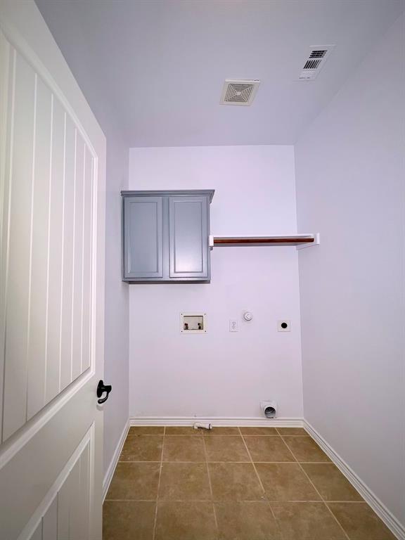 1902 Downing Street Allen, TX 75013 - Photo 13 of 19 Laundry room featuring gas dryer hookup, dark tile patterned floors, hookup for an electric dryer, washer hookup, and cabinet space
