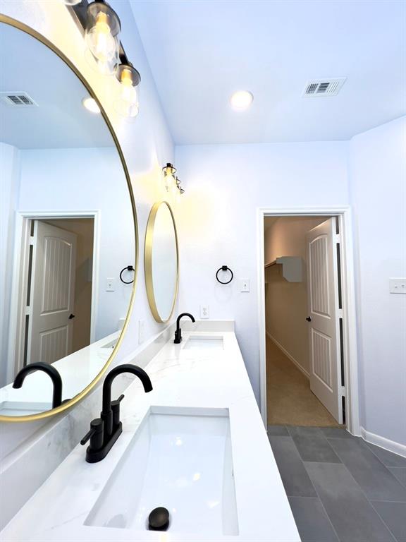 1902 Downing Street Allen, TX 75013 - Photo 17 of 19 Bathroom featuring a spacious closet, double vanity, recessed lighting, and dark tile patterned floors