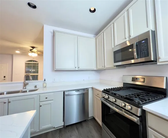 a kitchen with stainless steel appliances white cabinets and a stove top oven