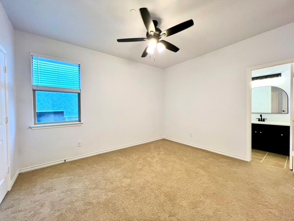 1902 Downing Street Allen, TX 75013 - Photo 10 of 19 Unfurnished bedroom featuring light colored carpet, a ceiling fan, ensuite bathroom, and arched walkways