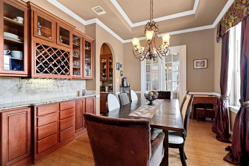 117 Citation Drive Cresson, TX 76035 - Photo 11 of 40 Dining area with a raised ceiling, light wood-style floors, arched walkways, a chandelier, and crown molding
