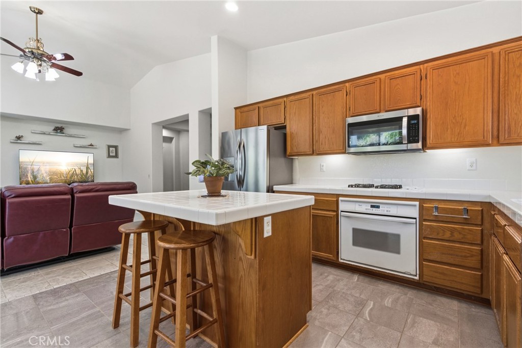 33145 Vermont Road Temecula, CA 92592 - Photo 18 of 41 a kitchen with stainless steel appliances granite countertop wooden cabinets a stove top oven a sink and dishwasher