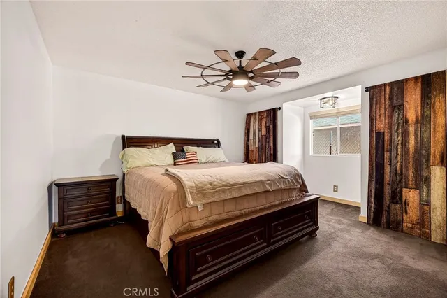 an empty room with wooden floor chandelier fan and windows
