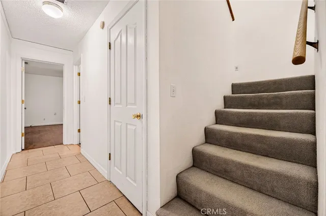 an empty room with wooden floor closet and fan