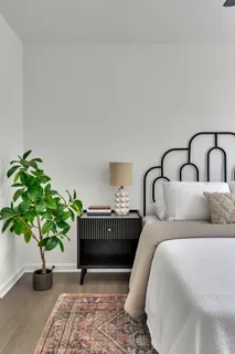 a bedroom with bed and a potted plant