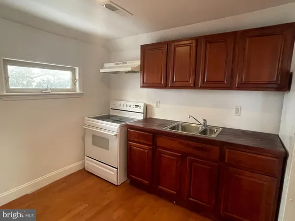 a kitchen with a refrigerator and a stove top oven