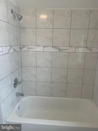 a white bath tub sitting next to a toilet