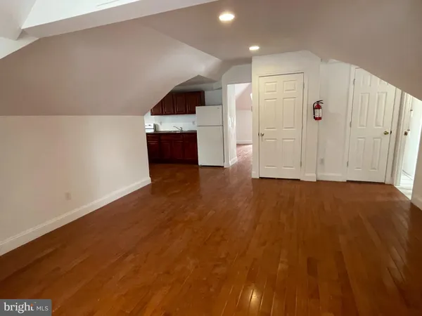 an empty room with wooden floor and closet
