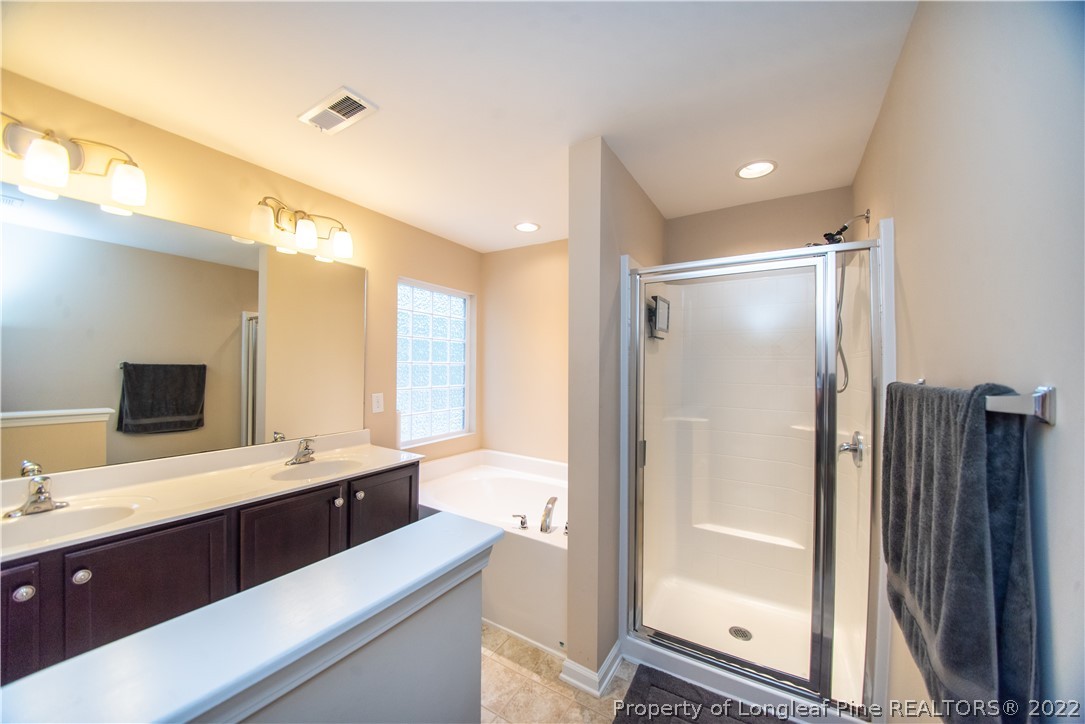 31 High Green Point Cameron, NC 28326 - Photo 24 of 44 a bathroom with a double vanity sink a mirror and a shower