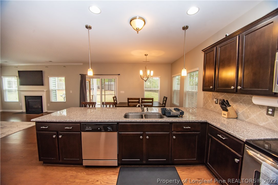 31 High Green Point Cameron, NC 28326 - Photo 8 of 44 a kitchen with stainless steel appliances granite countertop a sink a stove and a wooden floors