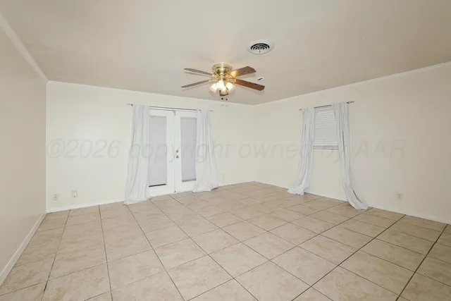 a view of an empty room and chandelier fan