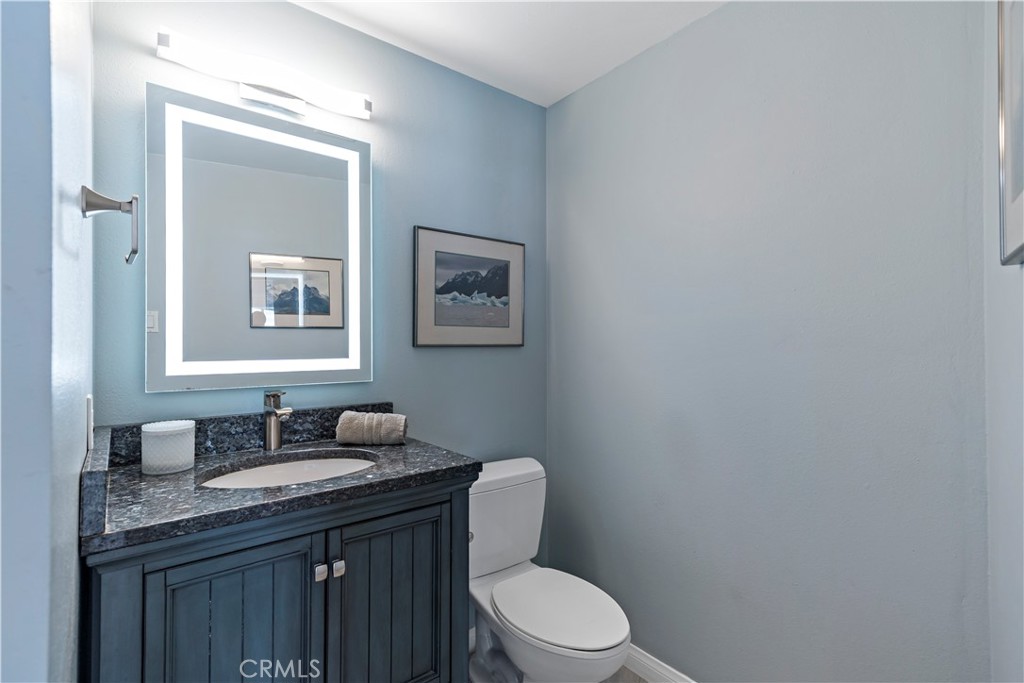 700 East Ocean Boulevard, Unit 3003 Long Beach, CA 90802 - Photo 16 of 35 a bathroom with a granite countertop toilet sink and mirror
