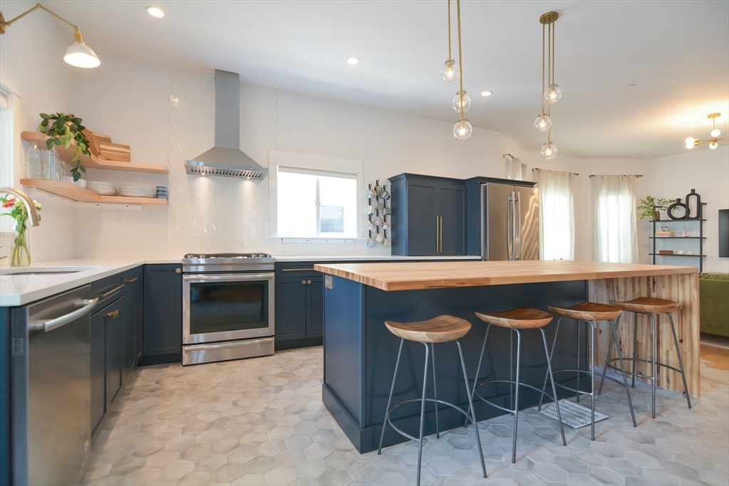 a kitchen with stainless steel appliances granite countertop a stove a sink island and a refrigerator