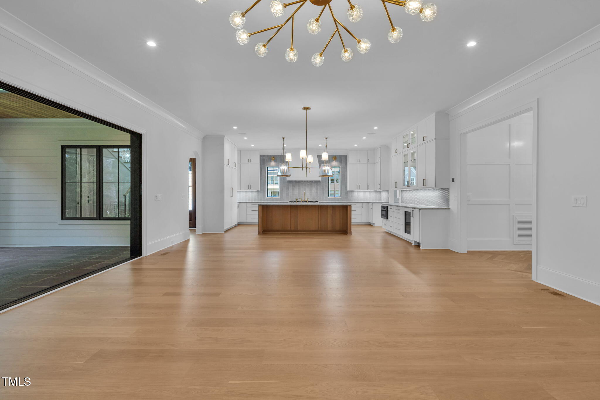 323 Hudson Street Raleigh, NC 27608 - Photo 22 of 52 a view of a kitchen with a refrigerator kitchen island cabinets and wooden floor