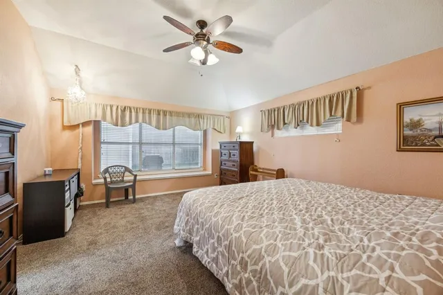 a bedroom with a large bed and a chandelier