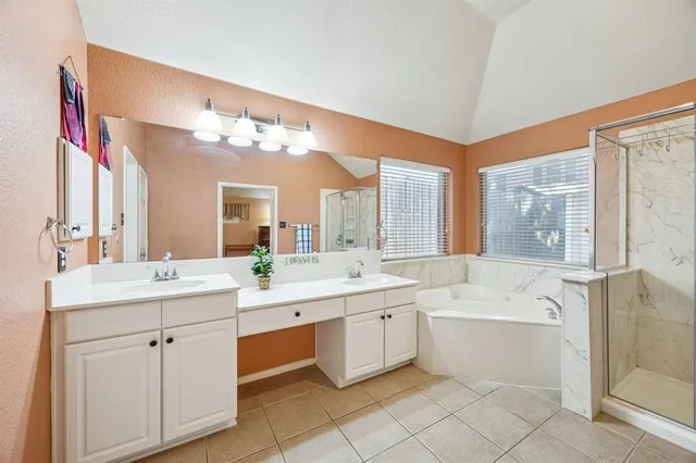 a large white bathroom with a double vanity sink mirror and bathtub