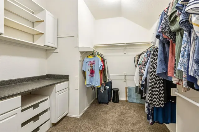a view of walk in closet with clothes