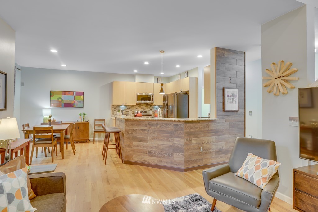 102 South 49th Street, Unit A Renton, WA 98055 - Photo 11 of 35 a living room with couches and kitchen view with wooden floor