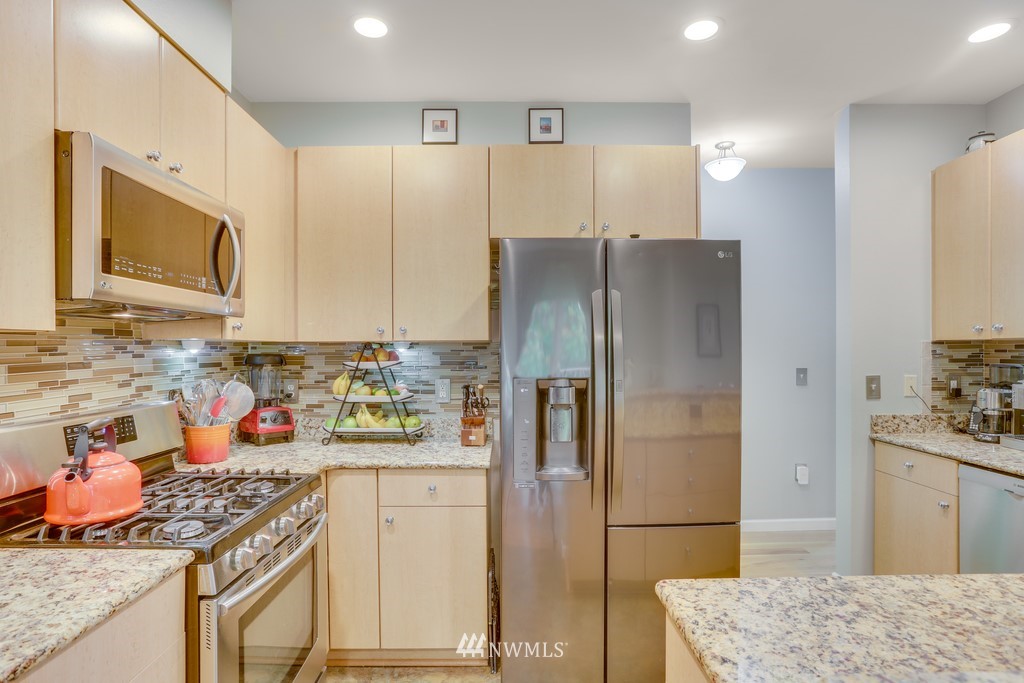 102 South 49th Street, Unit A Renton, WA 98055 - Photo 14 of 35 a kitchen with stainless steel appliances granite countertop a refrigerator and a stove top oven
