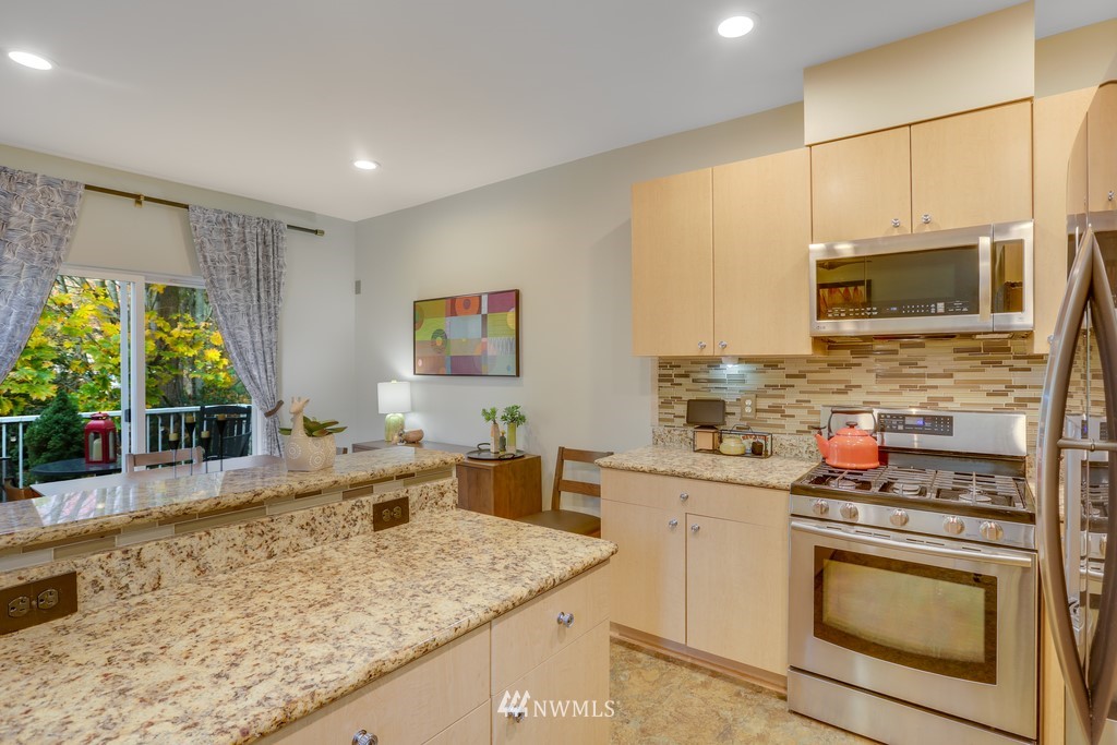 102 South 49th Street, Unit A Renton, WA 98055 - Photo 16 of 35 a kitchen with stainless steel appliances granite countertop a stove a sink and a microwave