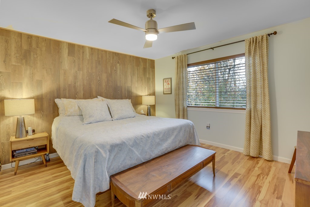 102 South 49th Street, Unit A Renton, WA 98055 - Photo 18 of 35 a bedroom with a bed and wooden floor