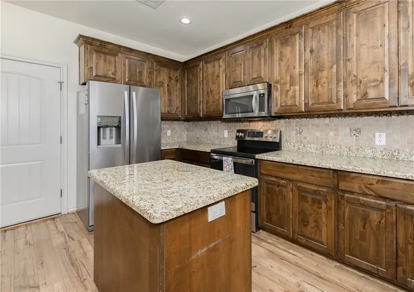 a kitchen with stainless steel appliances granite countertop a refrigerator sink and cabinets