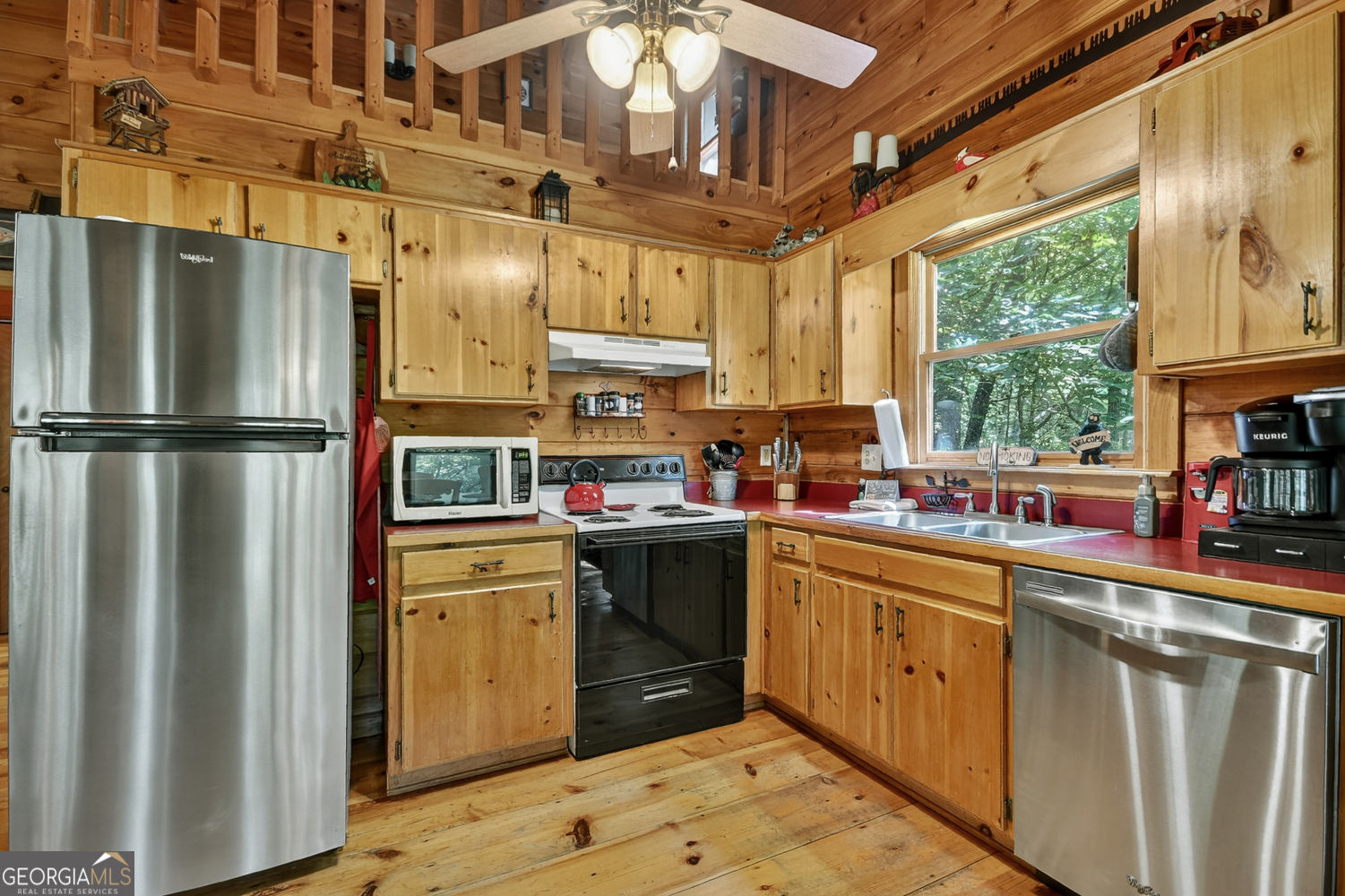135 Tomahawk Trail Blue Ridge, GA 30513 - Photo 31 of 54 a kitchen with stainless steel appliances granite countertop a refrigerator a sink dishwasher a stove and white countertops with wooden floor
