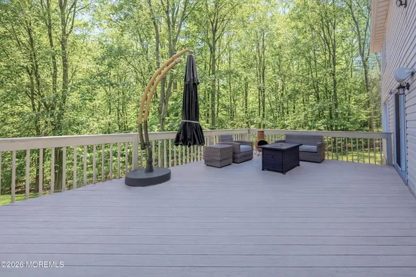 a kitchen with granite countertop a refrigerator a stove top oven a sink dishwasher and white cabinets with wooden floor