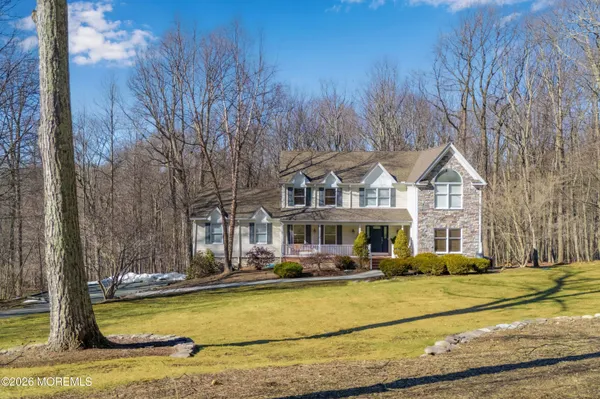 a front view of residential houses with yard and trees
