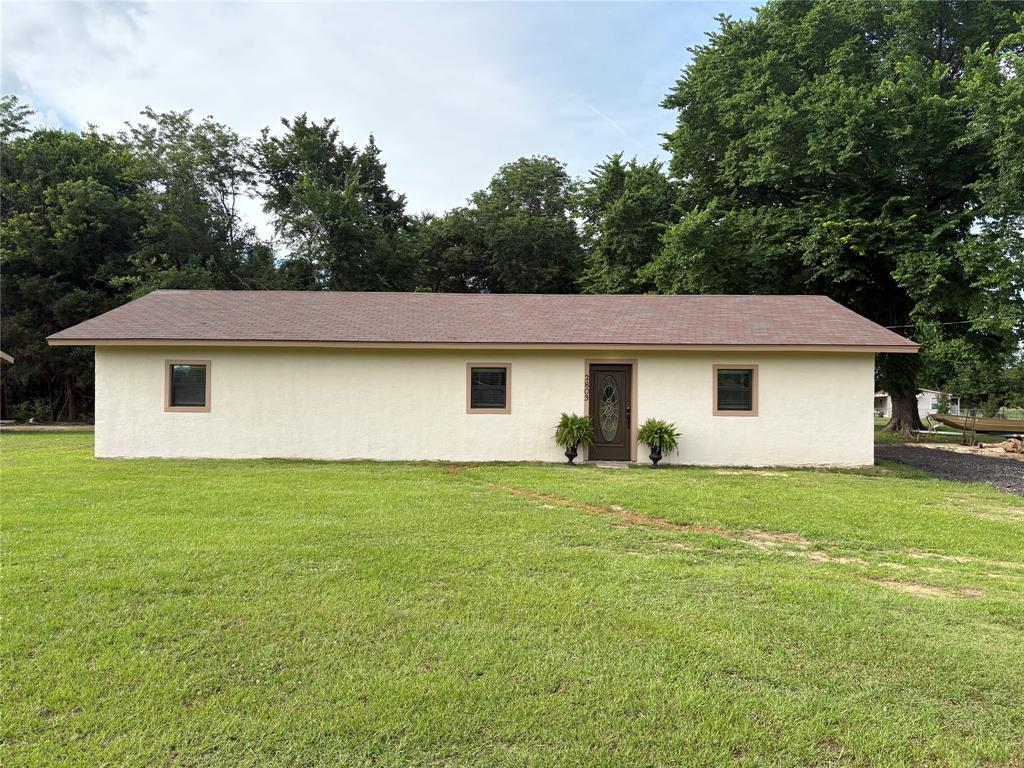 2803 County Road Powderly, TX 75473 - Photo 1 of 1 View of side of home featuring a yard and stucco siding